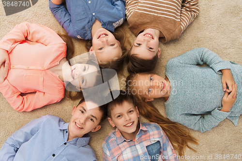 Image of happy smiling children lying on floor in circle