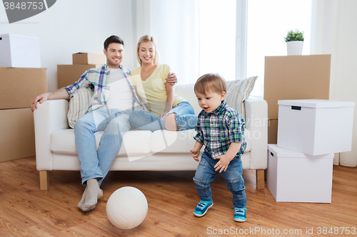 Image of happy family moving to new home and playing ball