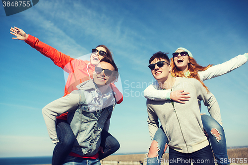 Image of happy friends in shades having fun outdoors