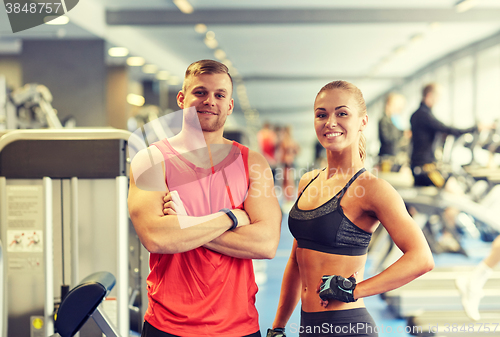 Image of smiling man and woman in gym