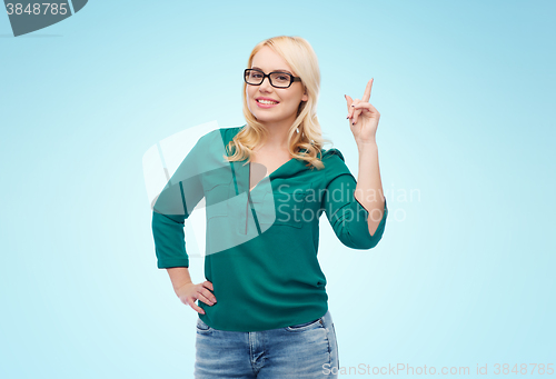 Image of young woman with eyeglasses pointing finger up