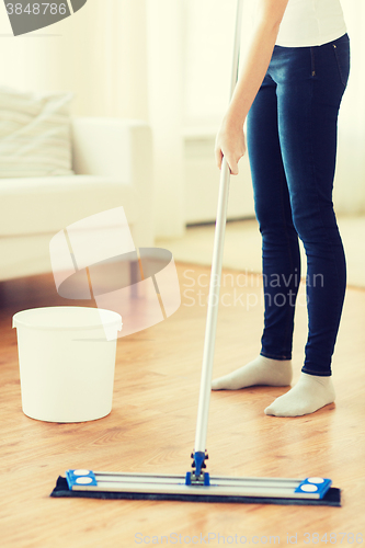 Image of close up of woman with mop cleaning floor at home