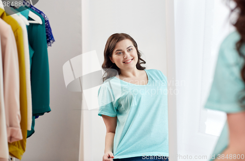 Image of happy plus size woman posing at home mirror
