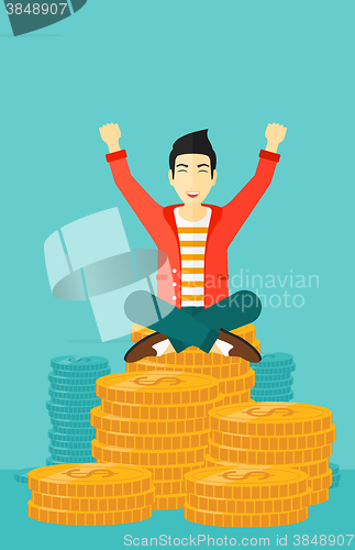 Image of  Happy businessman sitting on coins.