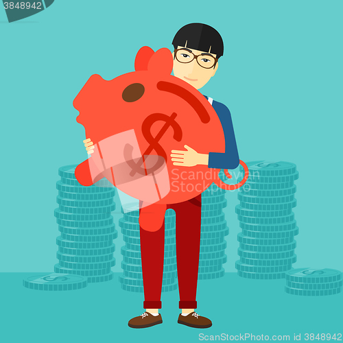 Image of Man carrying piggy bank.