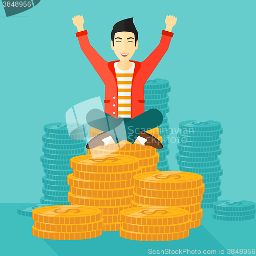 Image of  Happy businessman sitting on coins.