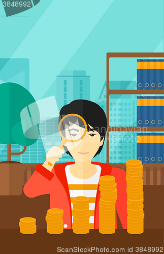 Image of Man with magnifier and golden coins. 