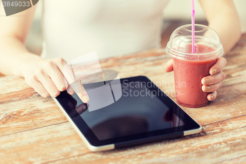 Image of close up of woman with tablet pc and smoothie
