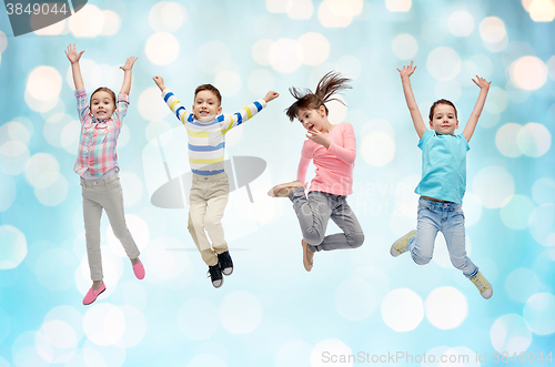 Image of happy little children jumping over blue lights