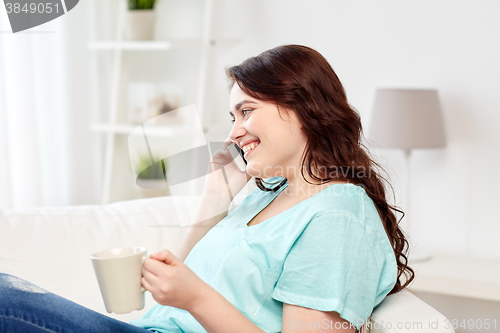 Image of plus size woman calling on smartphone at home