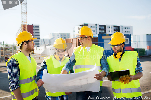 Image of group of builders with tablet pc and blueprint