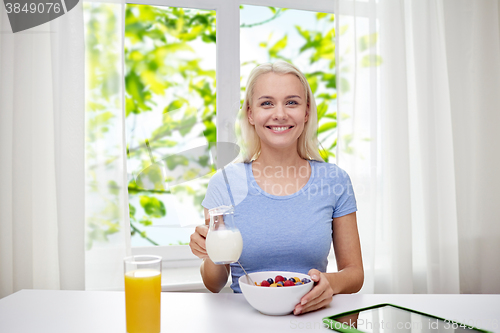 Image of woman with milk and cornflakes eating breakfast