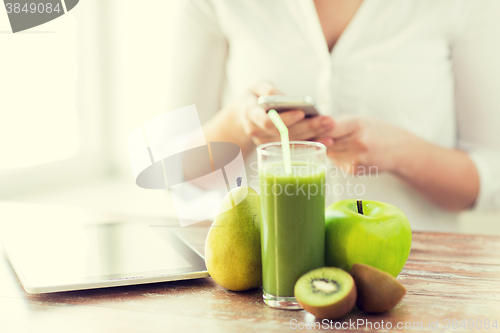 Image of close up of woman with smartphone and fruits
