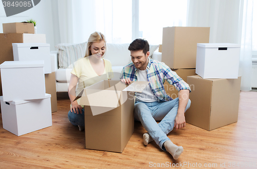 Image of smiling couple with big boxes moving to new home