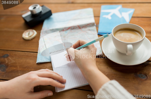 Image of close up of traveler hands with notepad and pencil
