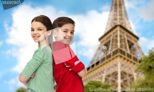 Image of happy boy and girl standing over eiffel tower