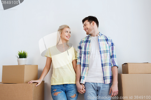Image of smiling couple with big boxes moving to new home