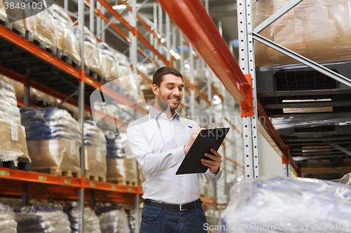 Image of businessman with clipboard at warehouse