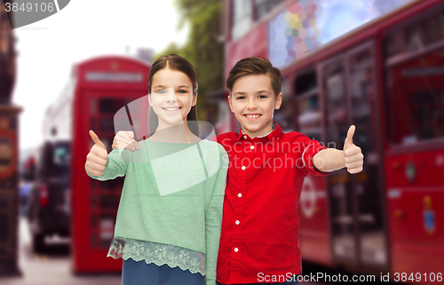 Image of happy children showing thumbs up over london city