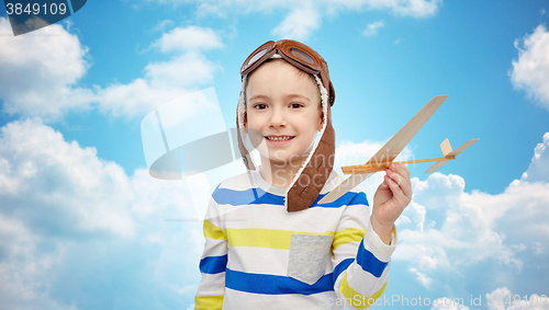 Image of happy little boy in aviator hat with airplane