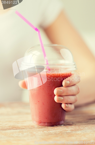 Image of close up of woman holding cup with smoothie