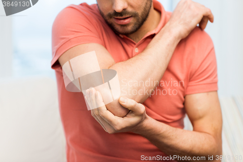 Image of close up of man with injured hand at home