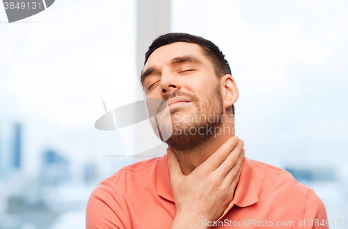 Image of unhappy man suffering from throat pain at home