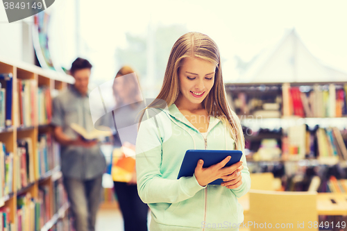 Image of happy student girl with tablet pc in library