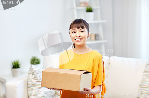 Image of happy asian young woman with parcel box at home