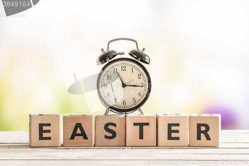 Image of Alarm clock on a wooden easter sign