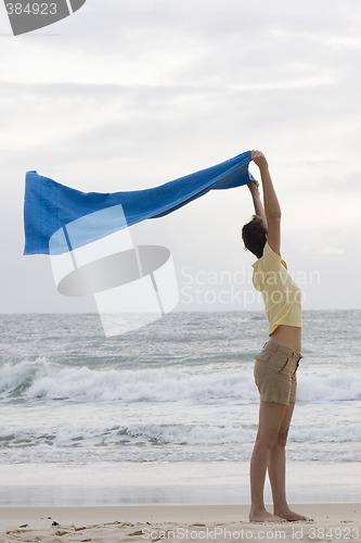 Image of Woman with towel on beach