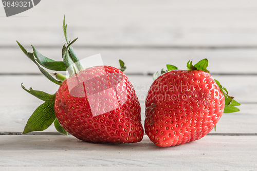 Image of Two strawberries on a wooden table
