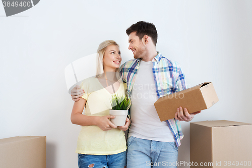 Image of smiling couple with big boxes moving to new home