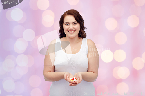 Image of happy plus size woman in underwear with pills