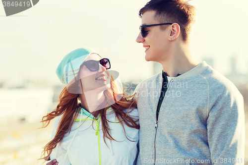 Image of happy teenage couple walking in city