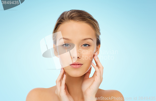 Image of young woman touching her face