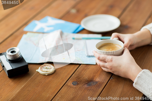 Image of close up of hands with coffee cup and travel stuff