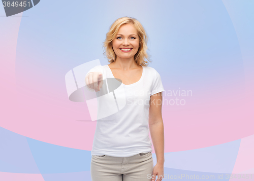 Image of smiling woman in white t-shirt pointing to you