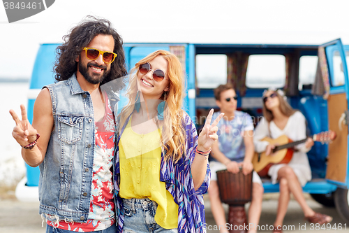 Image of hippie friends over minivan car showing peace sign