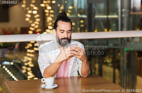 Image of man with smartphone and coffee at restaurant