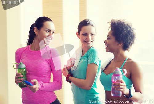 Image of happy women with bottles of water in gym