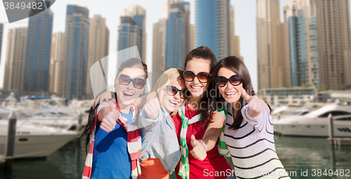 Image of young women showing thumbs up over city harbour