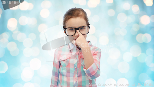Image of happy little girl in eyeglasses over blue lights