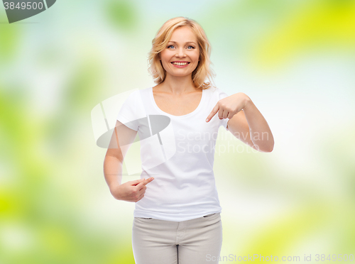 Image of smiling woman in white t-shirt pointing to herself