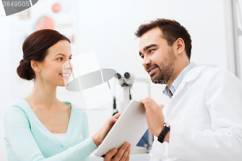 Image of optician with tablet pc and patient at eye clinic