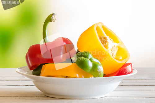 Image of Plate with pepper fruit on a wooden table