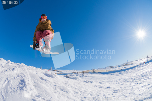 Image of Snowboarder jumping against blue sky