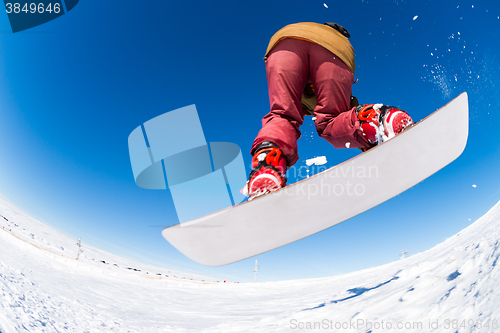 Image of Snowboarder jumping against blue sky