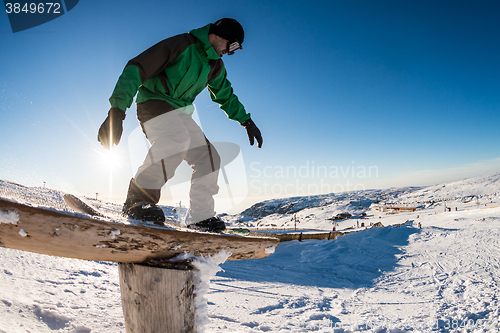 Image of Snowboarder sliding on a rail