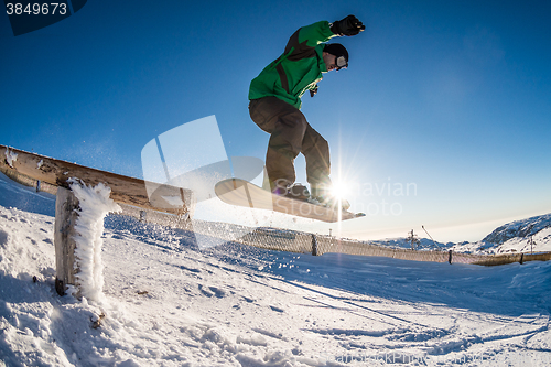 Image of Snowboarder jumping against blue sky